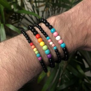 Pride Flag Beaded Bracelet. Rainbow and trans flag colored beads accented by black glass beads.