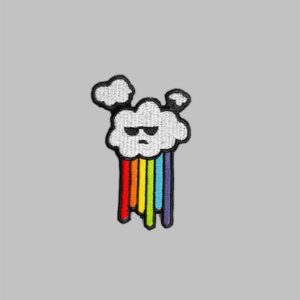 Iron on Rainbow Cloud Embroidery Patch. Design features a grey rain cloud with a rainbow falling instead of rain.